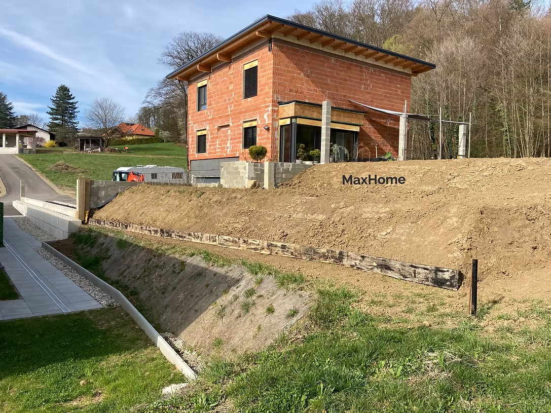 Hausbetreuer von MaxHome vor gepflegtem Wohnhaus